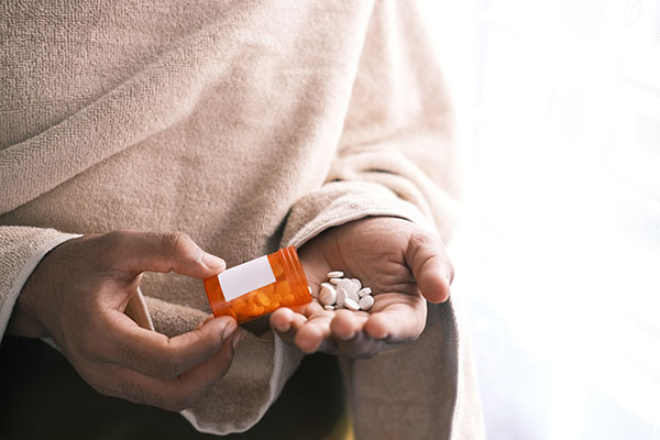 hands holding a prescription pill bottle